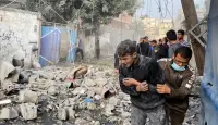 فلسطيني يساعد صبيا بعد غارة إسرائيلية على منزل في رفح، بجنوب قطاع غزة، 1 ديسمبر، 2023.  رويترز