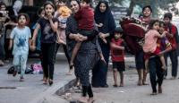 سيدة فلسطينية تحمل طفلها هربا من القصف الاسرائيلي