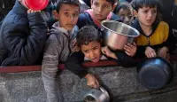 أطفال فلسطينيون ينتظرون الحصول على الطعام وسط نقص الإمدادات الغذائية، مع استمرار الحرب بين حماس وإسرائيل. رفح، جنوب قطاع غزة في 5 فبراير 2024. © رويتر