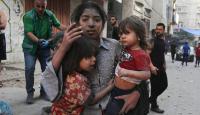 طفلة فلسطينية تحتضن اختيها بعد نجاتهم من غارة إسرائيلية
