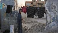 سيدة فلسطينية تنشر الغسيل على حطام منزلها