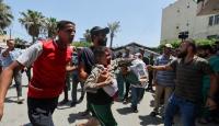 موتطن يحمل طفل مصاب جراء القصف الإسرائيلي
