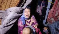 سيدة تحمل طفلها عقب غرق الخيمة جراء مياه الأمطار