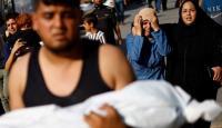 شاب يحمل طفل استشهد في قصف اسرائيلي