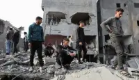 فلسطينيون يتفقدون الأضرار التي أسفرت عن غارة إسرائيلية على مخيم النصيرات للاجئين في وسط قطاع غزة. 7 ديسمبر 2024 - REUTERS