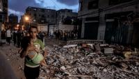فلسطيني يحمل طفله بعد قصف إسرائيلي على غزة (علي جادالله - الأناضول)