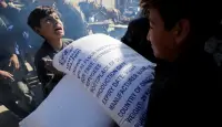 اطفال يحملون كيس طحين - صورة أرشيفية