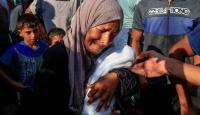 امرأة تحمل طفل استشهد جراء التجويع