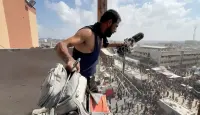 رجل يحمل المعدات التي استخدمها المصور الفلسطيني حسام المصري، في الموقع الذي قتل فيه مع صحفيين وأشخاص آخرين في غارات إسرائيلية على مستشفى ناصر، في خان يونس جنوب قطاع غزة، في 25 أغسطس الماضي (نقلاً عن وكالة "رويترز")