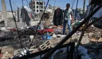 فلسطيني يحمل جاكيت الشاب مهند فروانة الذي قتلته غارة إسرائيلية بينما كان يتجهز لحفل زفافه ظهر اليوم في خان يونس جنوب قطاع غزة (إ.ب.أ)