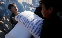 اطفال يحملون كيس طحين - صورة أرشيفية