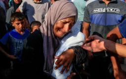 امرأة تحمل طفل استشهد جراء التجويع