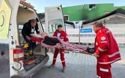 طواقم الهلال الاحمر ينقلون مريضا الى سيارة الاسعاف