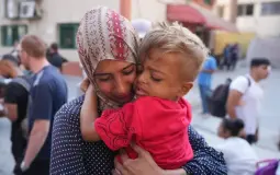 طفل مريض يتشبث بأمه قبل مغادرته غزة مع جدته - أسوشييتد برس