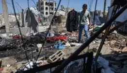 فلسطيني يحمل جاكيت الشاب مهند فروانة الذي قتلته غارة إسرائيلية بينما كان يتجهز لحفل زفافه ظهر اليوم في خان يونس جنوب قطاع غزة (إ.ب.أ)