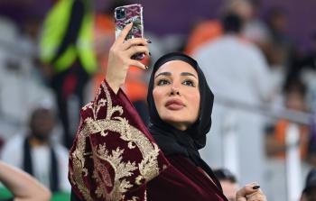 مشجعة لكرة القدم بالزي القطري التقليدي في مدرجات استاد 