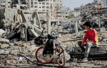 فتى يجلس على ركام منزل في قطاع غزة - GETTY IMAGES