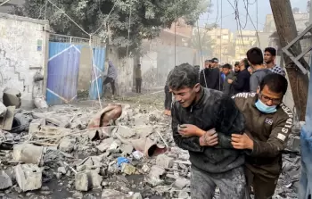 فلسطيني يساعد صبيا بعد غارة إسرائيلية على منزل في رفح، بجنوب قطاع غزة، 1 ديسمبر، 2023.  رويترز