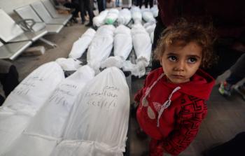 طفلة أمام جثامين شهداء من عائلتها في غزة