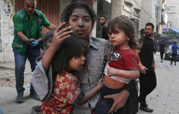 طفلة فلسطينية تحتضن اختيها بعد نجاتهم من غارة إسرائيلية