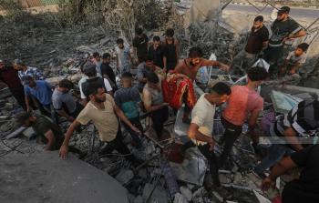 مواطنون يبحثون بين الأنقاض عن مفقودين بعد غارة جوية إسرائيلية على احد البركسات التجارية في حي الزوايدة وسط قطاع غزة