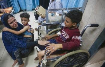 ام تحاول تهدئة أطفالها بعد قصف الاحتلال