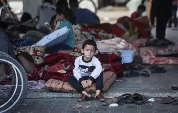 ولد صغير يجلس على فرشة في ساحة