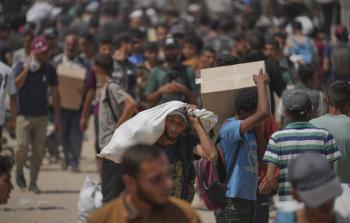 فلسطينيون يحملون مساعدات غذائية في رفح يوم 6 يونيو 2025 (أ.ب)