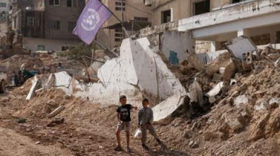 طفلان يمران بجوار مكان دمره الطيران الحربي الإسرائيلي