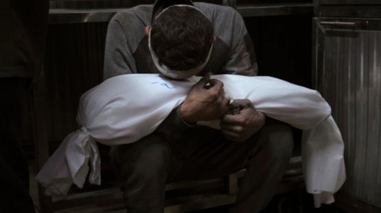 أب يحتضن طفله الشهيد