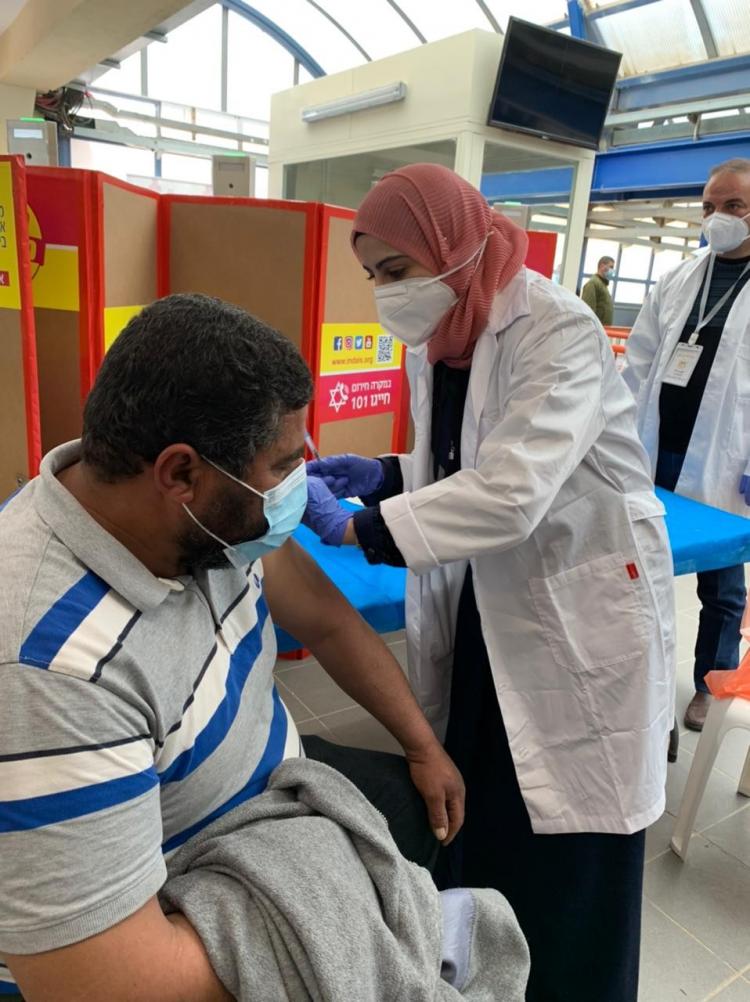 طبيبة فلسطينية تقوم بتطعيم العمال