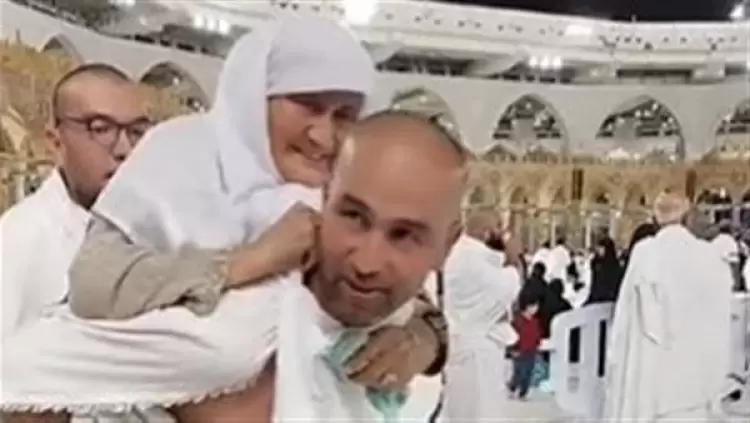 شاب يحمل والدته أمام الحرم المكي