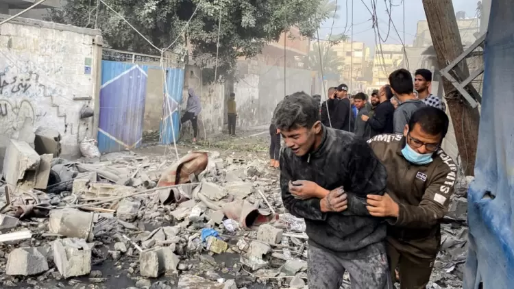 فلسطيني يساعد صبيا بعد غارة إسرائيلية على منزل في رفح، بجنوب قطاع غزة، 1 ديسمبر، 2023.  رويترز