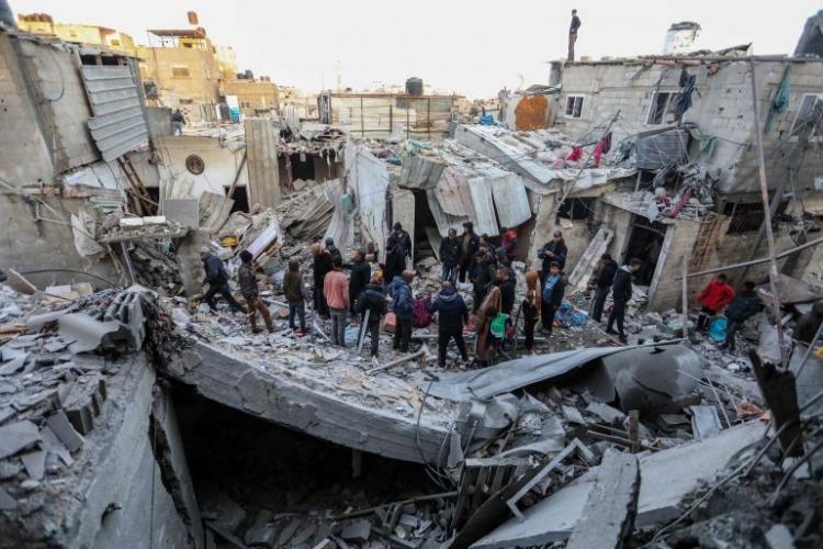 مواطنون يتفقدون منزلاً عقب قصفه من قبل طائرات الاحتلال - غيتي
