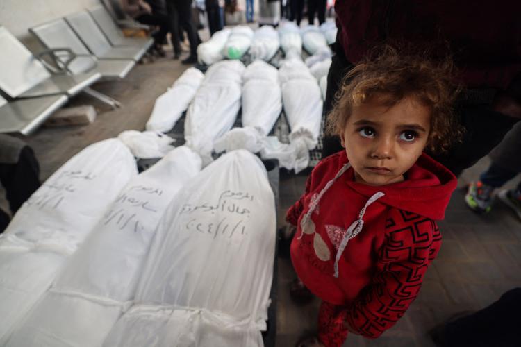 طفلة أمام جثامين شهداء من عائلتها في غزة
