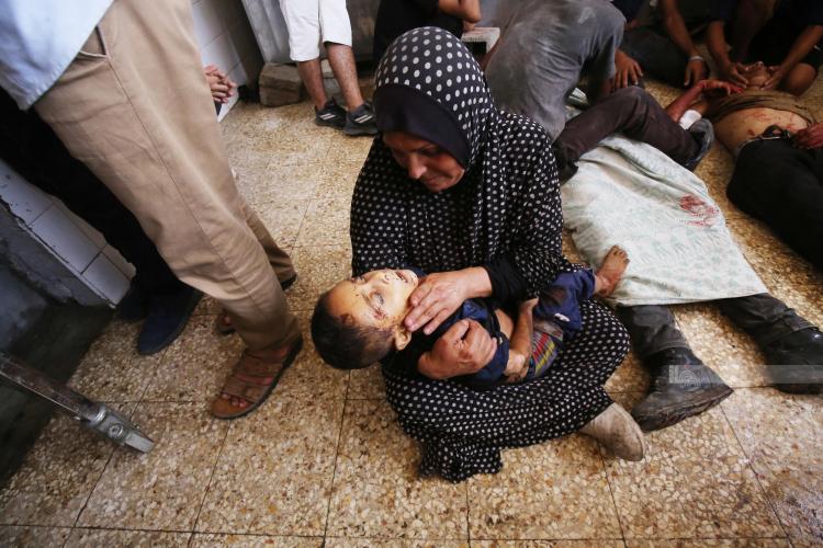 سيدة تودع طفلها الذي استشهد مع عدد من أفراد العائلة في المحافظة الوسطى