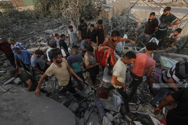 مواطنون يبحثون بين الأنقاض عن مفقودين بعد غارة جوية إسرائيلية على احد البركسات التجارية في حي الزوايدة وسط قطاع غزة