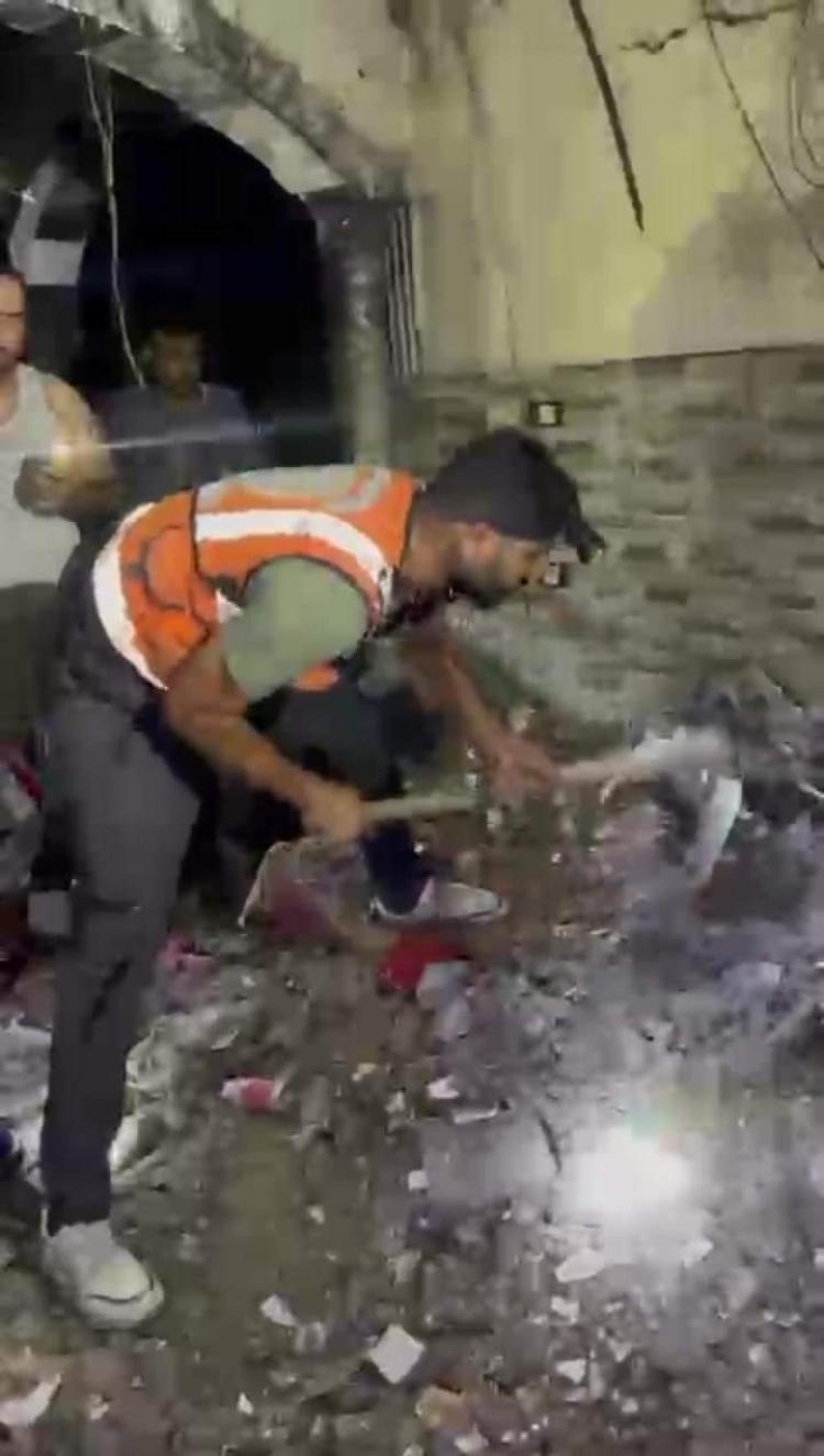 أحد عناصر الدفاع المدني يحاول انقاذ مواطنين تحت الأنقاص