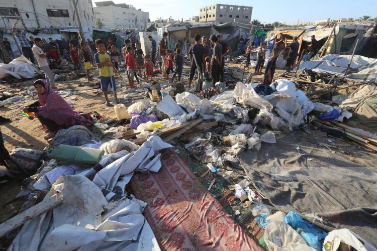 مواطنون يتفقدون الدمار الذي أصاب خيام النازحين في مخيم إيواء داخل مستشفى شهداء الأقصى بعد استهدافهم من قبل طائرات الاحتلال الاسرائيلي
