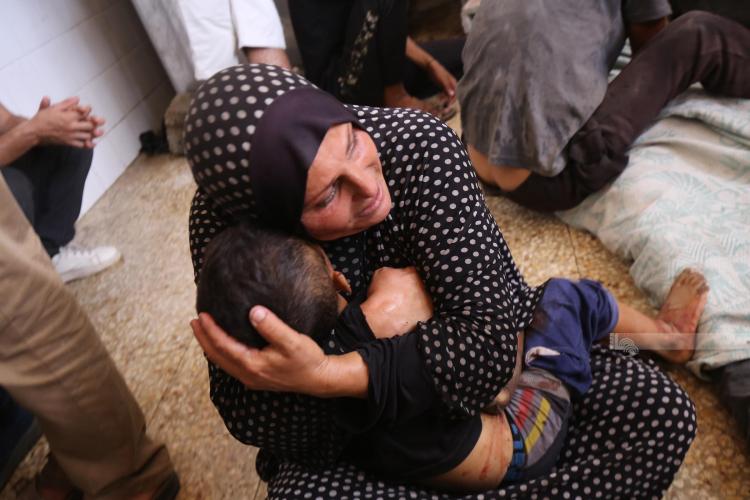 أم تودع طفلها الذي استشهد جراء قصف طائرات الاحتلال