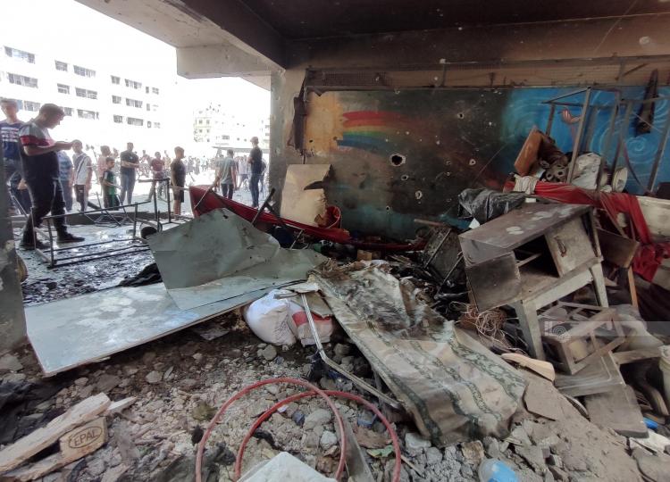 مواطنون يعملون على اجلاء شهداء ومصابين من تحت الركام بعد قصف طيران الاحتلال مدرسة الفلاح في مدينة غزة