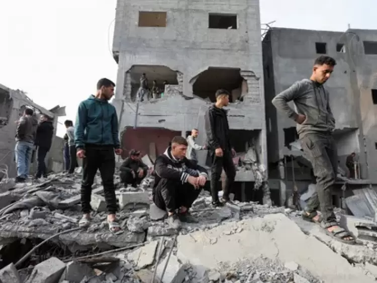 فلسطينيون يتفقدون الأضرار التي أسفرت عن غارة إسرائيلية على مخيم النصيرات للاجئين في وسط قطاع غزة. 7 ديسمبر 2024 - REUTERS
