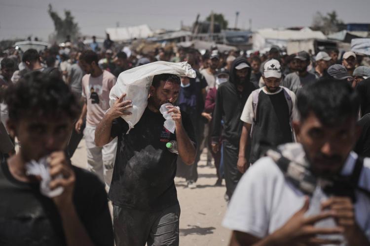 يحمل فلسطينيون صناديق وأكياساً تحتوي على مساعدات غذائية وإنسانية قدمتها «مؤسسة غزة الإنسانية» وهي منظمة مدعومة من الولايات المتحدة ووافقت عليها إسرائيل في رفح (أ.ب)