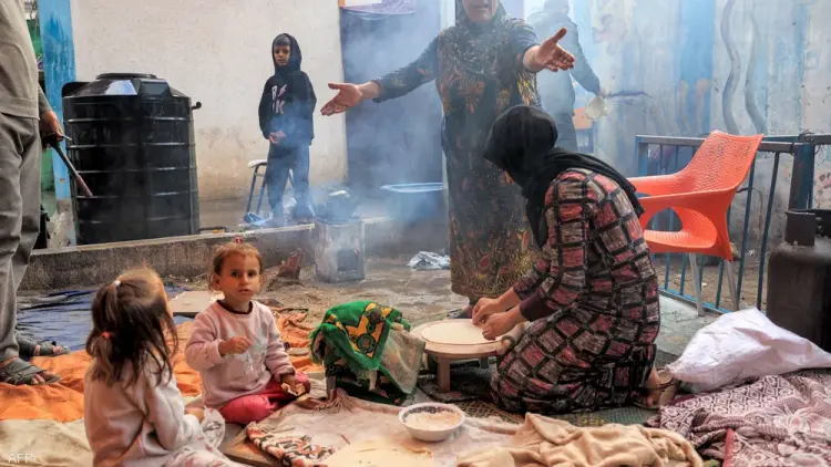 أم تعد الخبز التقليدي لإطعام صغارها في غزة