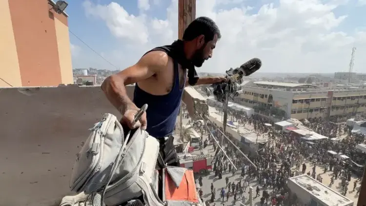 رجل يحمل المعدات التي استخدمها المصور الفلسطيني حسام المصري، في الموقع الذي قتل فيه مع صحفيين وأشخاص آخرين في غارات إسرائيلية على مستشفى ناصر، في خان يونس جنوب قطاع غزة، في 25 أغسطس الماضي (نقلاً عن وكالة "رويترز")