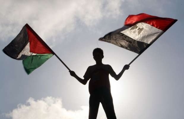 فتى فلسطيني يحمل العلمين المصري والفلسطيني