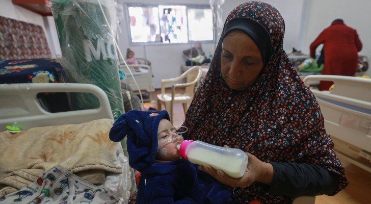 سيدة فلسطينية ترضع طفل